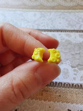 Load image into Gallery viewer, One pair of crescent moon earring studs held between finger and thumb