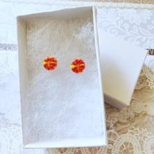 Load image into Gallery viewer, A pair of round yellow and red stud earrings inside a white paper jewelry box