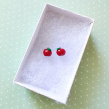 Load image into Gallery viewer, A pair of miniature apple earrings inside a white paper jewelry box