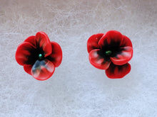 Load image into Gallery viewer, A pair of red and black flower shaped earrings with green metallic centers