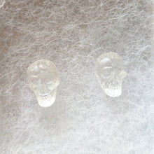Load image into Gallery viewer, A close up picture of a pair of clear skull stud earrings.