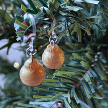 Load image into Gallery viewer, One pair of miniature gold baubles with a reflective textured surface. The earrings are shown hanging from an artificial Christmas tree branch.