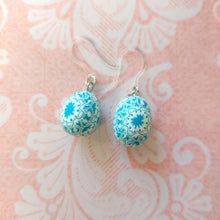 Load image into Gallery viewer, Patterned Easter egg shaped dangle earrings in a blue and white one a pink paper background.