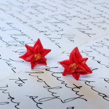 Load image into Gallery viewer, A close up of a pair of red poinsettia earrings.
